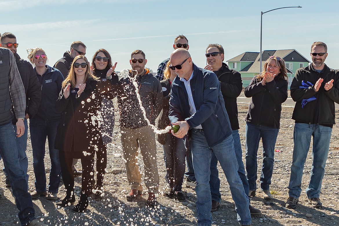 Rob Nalle, senior project manager for Simplicity by Hayden Homes, pours out a bottle of champagne to christen the Polo Ridge development in Moses Lake.