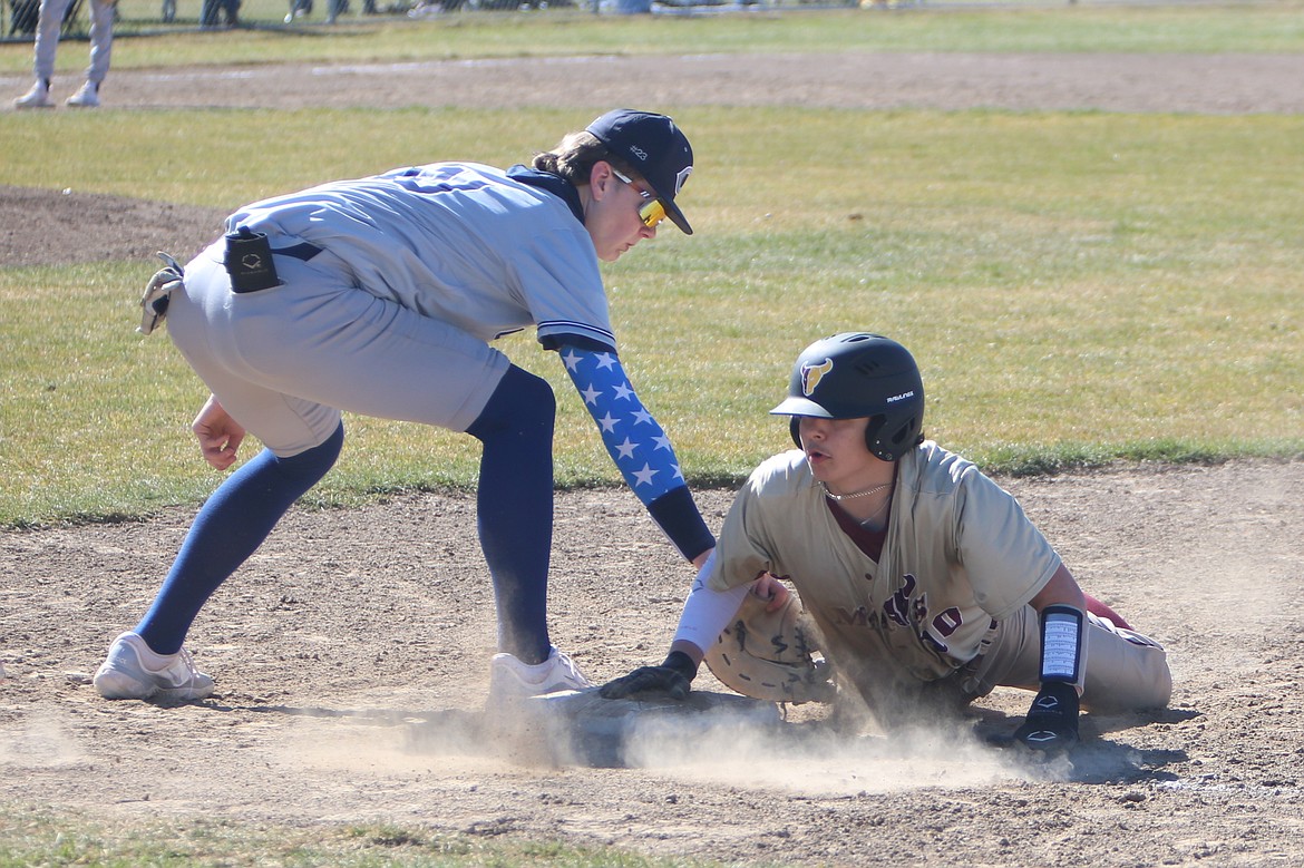 Moses Lake junior Cruz Martinez, right, survives a pick-off attempt at first base.