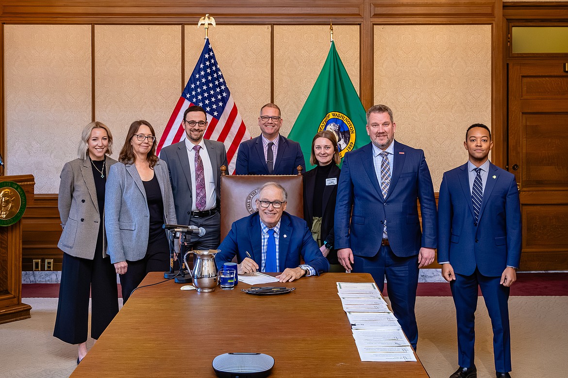 Washington Gov. Jay Inslee, sitting, recently signed House Bill 1961, aimed at deterring acts of animal cruelty through increased criminal penalties, into law.