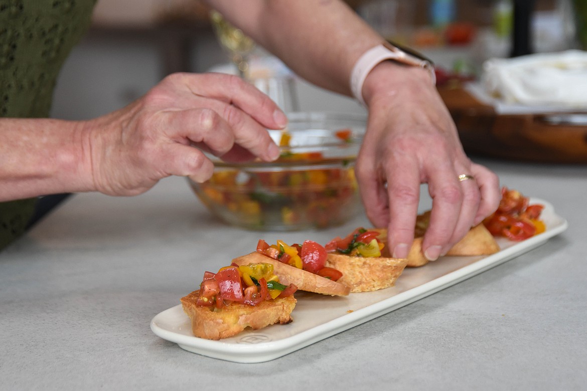 Gina Simmonds, author of "How to Cook Like Mom," arranges her bruschetta on March 21, 2024. (Kate Heston/Daily Inter Lake)