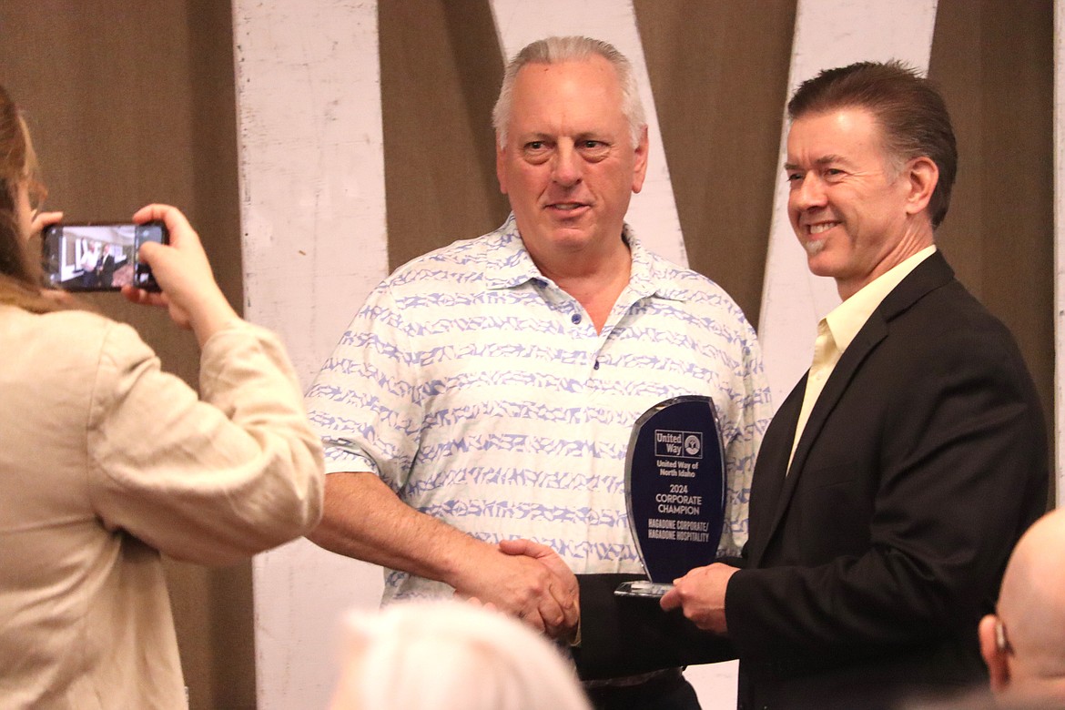 Eric Haakenson with the Hagadone Corp., left, accepts a Corporate Champion award from Mark Tucker, United Way of North Idaho executive director, on Thursday during the UWNI's annual awards luncheon.