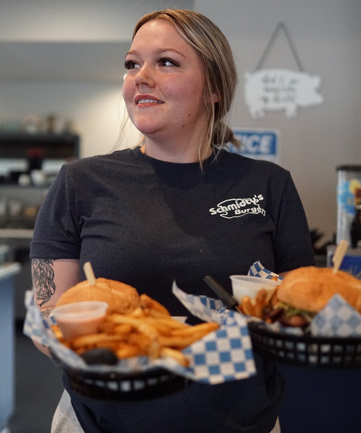 Hailey Reuter carries orders out to customers at Schmidty's Burgers on Friday.  Reuter has worker for Schmidty's for four years.