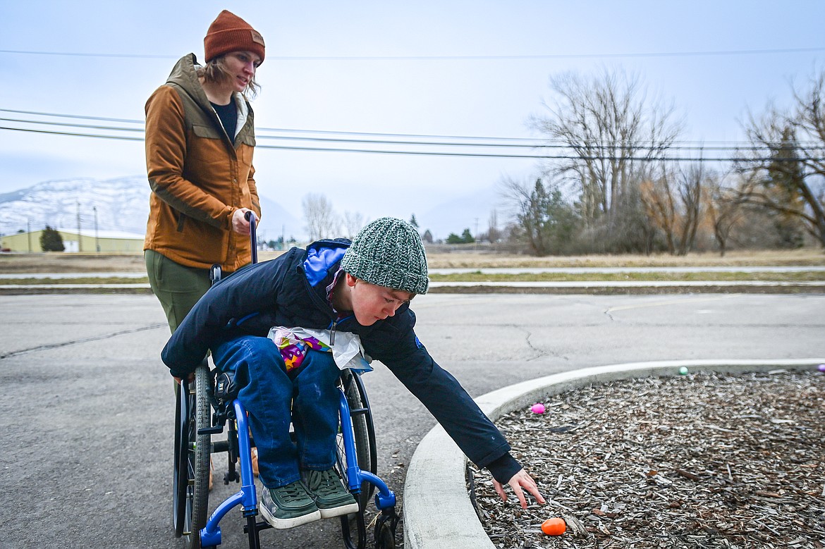 Jaxen Flores picks up eggs with his mother Erin Hoch during an Inclusive Easter Egg Hunt for kids with low vision, sensory or wheelchair and walker accessibility needs hosted by Healthy Beginnings Pediatric Therapy in Columbia Falls on Saturday, March 23. (Casey Kreider/Daily Inter Lake)
