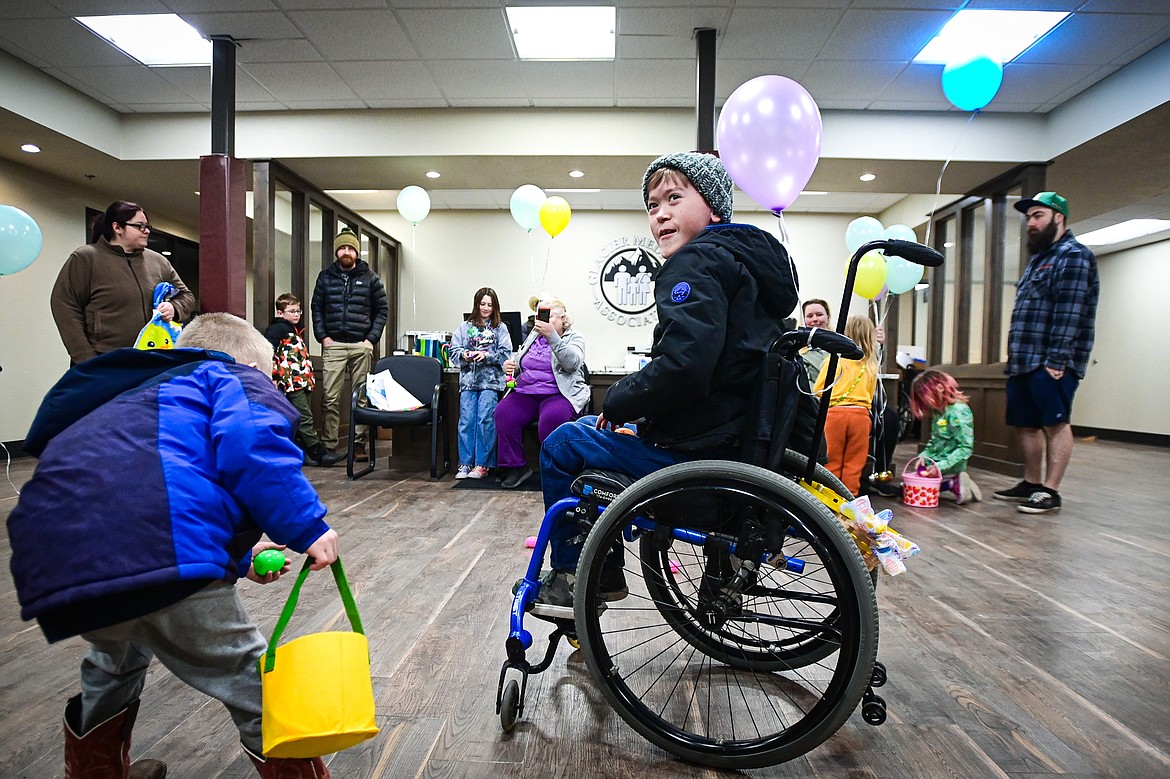 Jaxen Flores flashes a smile at his parents as he picks up eggs during an Inclusive Easter Egg Hunt for kids with low vision, sensory or wheelchair and walker accessibility needs at the Cedar Palace Medical Center in Columbia Falls on Saturday, March 23. Healthy Beginnings Pediatric Therapy hosted the event.(Casey Kreider/Daily Inter Lake)