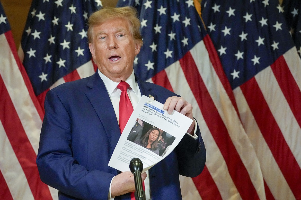 Former President Donald Trump holds up a copy of a story featuring New York Attorney General Letitia James while speaking during a news conference, Jan. 11, 2024, in New York. Trump could find out Monday, March 25, how New York state aims to collect over $457 million he owes in his civil business fraud case, even as he appeals the verdict that led to the gargantuan debt. (AP Photo/Mary Altaffer, File)