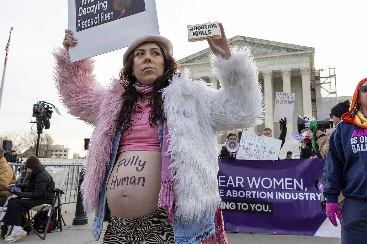 Melanie Salazar of the group Progressive Anti-Abortion Uprising, holds up a mock box of pills in front of the Supreme Court, Tuesday, March 26, 2024, in Washington. The Supreme Court is hearing arguments in its first abortion case since conservative justices overturned the constitutional right to an abortion two years ago. At stake in Tuesday's arguments is the ease of access to a medication used last year in nearly two-thirds of U.S. abortions. (AP Photo/Amanda Andrade-Rhoades)