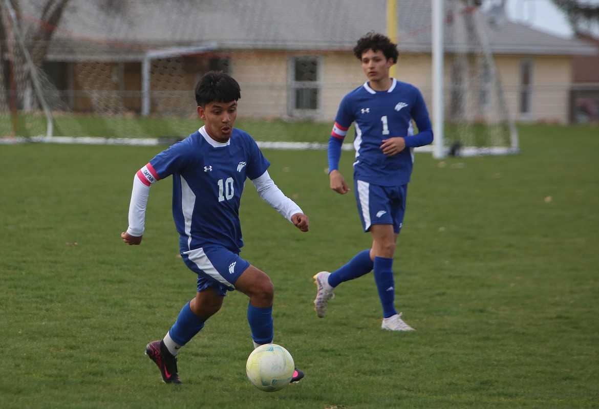 Warden junior Oscar Dominguez (10) brings the ball upfield against Connell Monday evening.