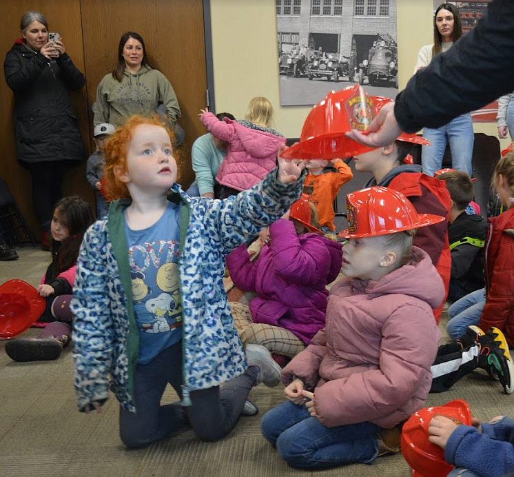 Madison Garcia reaches for a fire hat Tuesday at the Shoshone Fire District No. 1 station. Garcia was part of a group from Silver Hills Elementary School taking a tour of the fire station.