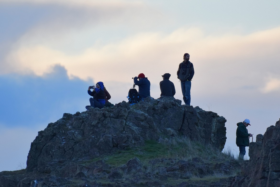 Bird watchers perch on top of a cliff above Scooteney Reservoir waiting for sandhill cranes to fly into the reservoir to roost the night of March 23.