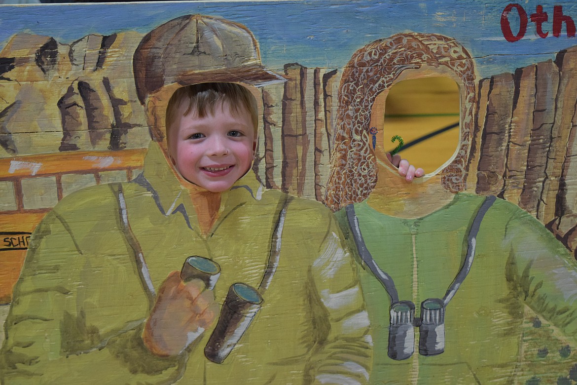 Garrett Bell sticks his head through a fun photo board, pretending to be a bird watcher during the 2024 Sandhill Crane Festival.