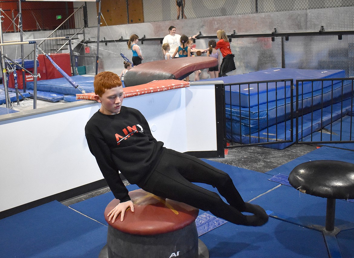 Kellen Farnsworth spins around on “the mushroom,” a practice device for pommel horse routines, at AIM Gymnastics Thursday.