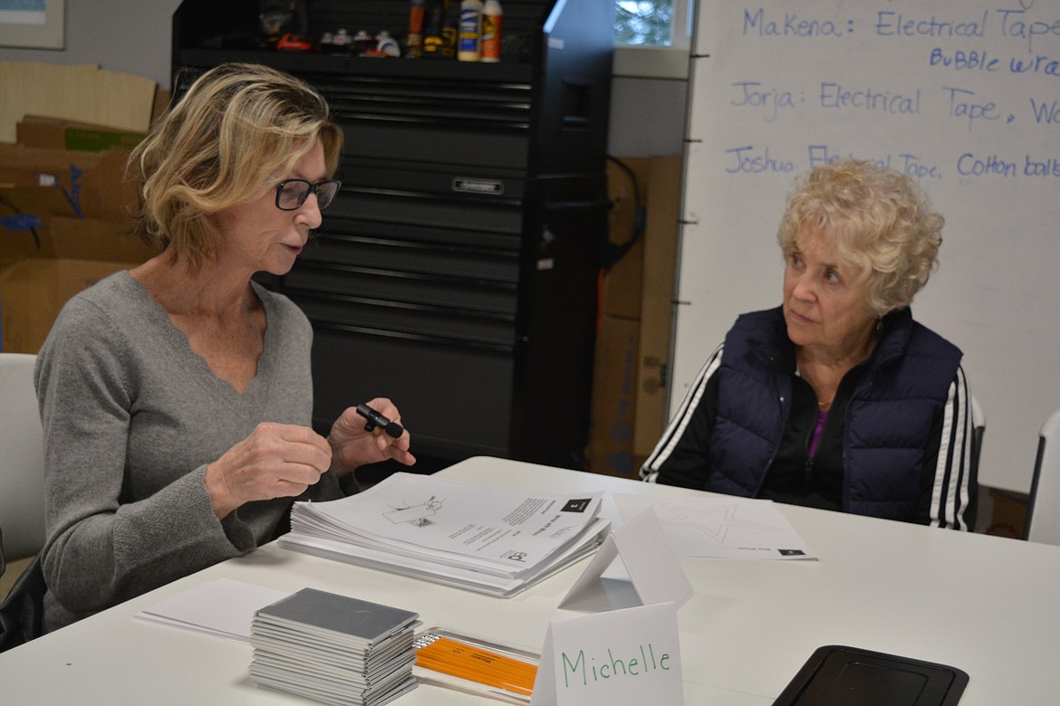 Wired2Learn hosted a dyslexia simulation and open house Thursday to help families and interested community members understand some of the complications dyslexia can pose in navigating common tasks in school. Michelle Conger explains the mirror writing exercise to Coeur d’Alene resident Joanna Adams.