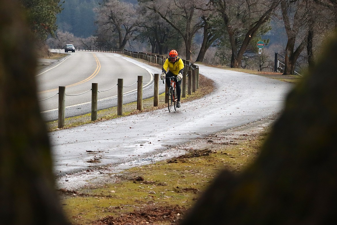 Jim Wyatt rides his bike on the North Idaho Centennial Trail along Coeur d'Alene Lake Drive on a recent morning.