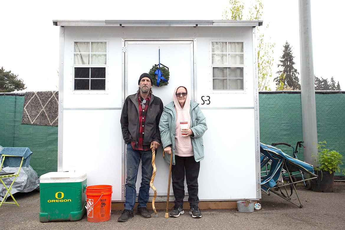 Residents stand outside a Pallet Homes structure at Vancouver’s Stay Safe Community. The temporary residences include heating and air conditioning and lockable doors and storage for comfort and safety.