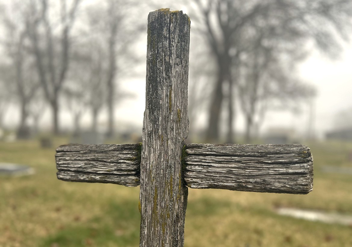 A wooden cross stands at St. Thomas Catholic Cemetery. Christians will celebrate the resurrection of Christ today, Easter Sunday.