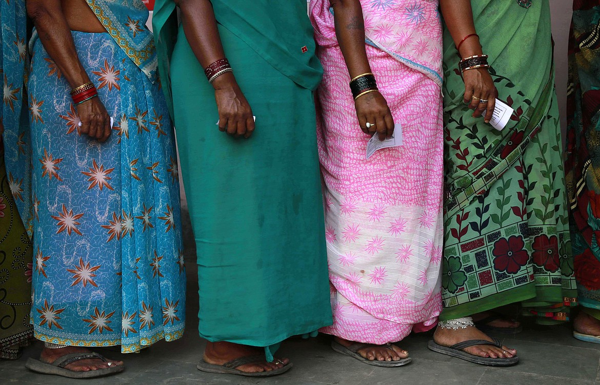 Indian women stand in a queue to cast their votes in Rajnandgaon, in the central Indian state of Chhattisgarh, April 17, 2014. With a population of over 1.4 billion people and close to 970 million voters, India’s 2024 general election will pit Prime Minister Narendra Modi, an avowed Hindu nationalist, against a broad alliance of opposition parties that are struggling to play catch up. (AP Photo/Rafiq Maqbool, File)