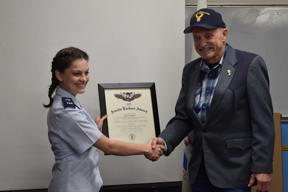 Civil Air Patrol Cadet Commander Daisy Carpenter, left, receives the CAP’s Amelia Earhart Award from Rep. Tom Dent, R-Moses Lake, Thursday evening at Ephrata’s Camp Boucher.