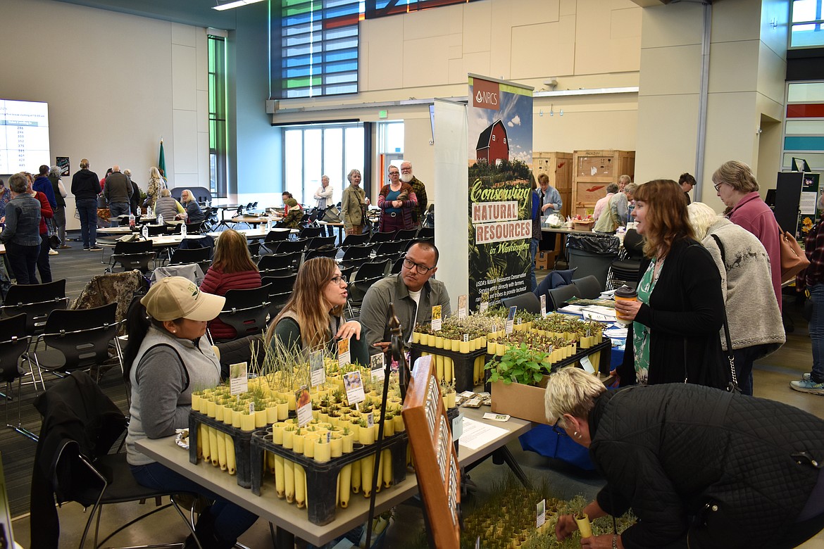 From left: Edith Gonzalez, Linda Duran and Rico Duran, of BFI Natural Seeds, discuss a variety of plants with attendees at the 2023 Columbia Basin Eco-Gardening Symposium. This year’s symposium is April 20.