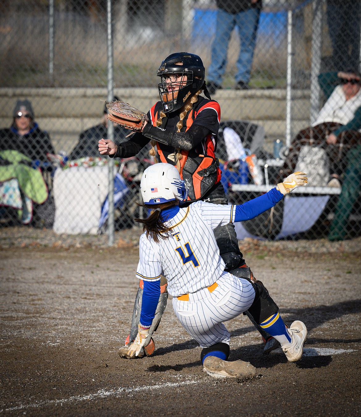 Thompson Falls pitcher Olivia Fitchett (4) slides into home with a run while Plains catcher Taylor Saner awaits the throw during their game this past Thursday in Plains. (Photo by Tracy Scott)