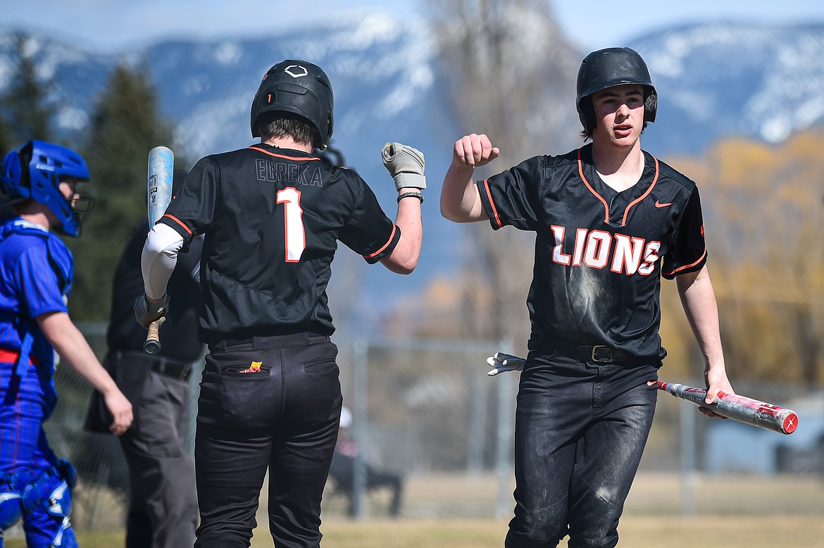 Eureka's Tristan Libby (1) congratulates Emmett McKim (8) after McKim scored on a hit by Michael Van Glider (2) in the second inning against Bigfork at ABS Park in Evergreen on Tuesday, April 2. (Casey Kreider/Daily Inter Lake)