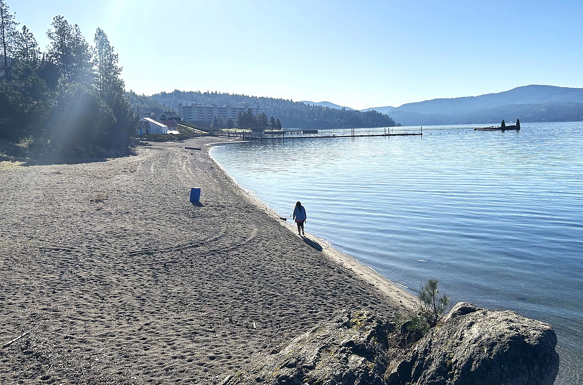 A walker strolls along the shoreline of Lake Coeur d'Alene fronting The Coeur d'Alene Resort Golf Course on Easter morning.