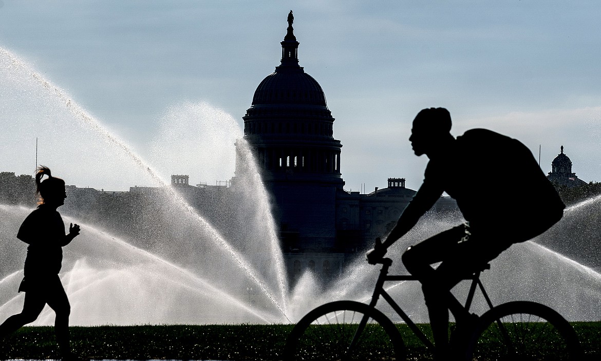 The Capitol is seen as water sprinklers soak the National Mall on a hot summer morning in Washington, July 15, 2022. A new poll finds that most Americans share many core values on what it means to be an American despite the country’s deep political polarization. The poll from The Associated Press-NORC Center for Public Affairs Research found that about 9 in 10 U.S. adults say the right to vote, the right to equal protection under the law and the right to privacy are important or very important to the U.S.’s identity as a nation.(AP Photo/J. Scott Applewhite)