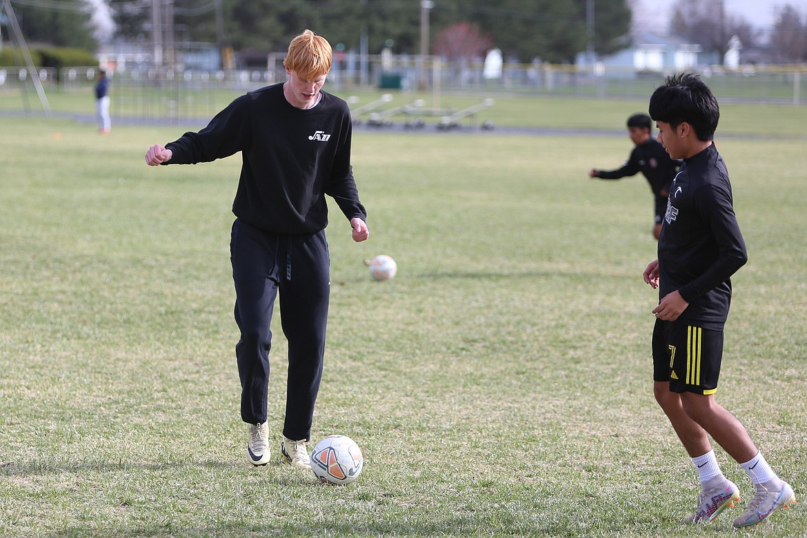 Othello senior Aksel Jebsen, left, works on a passing drill during a March 25 practice. Jebsen said classmates, teammates and coaches have been very welcoming to him during his year at Othello High School.