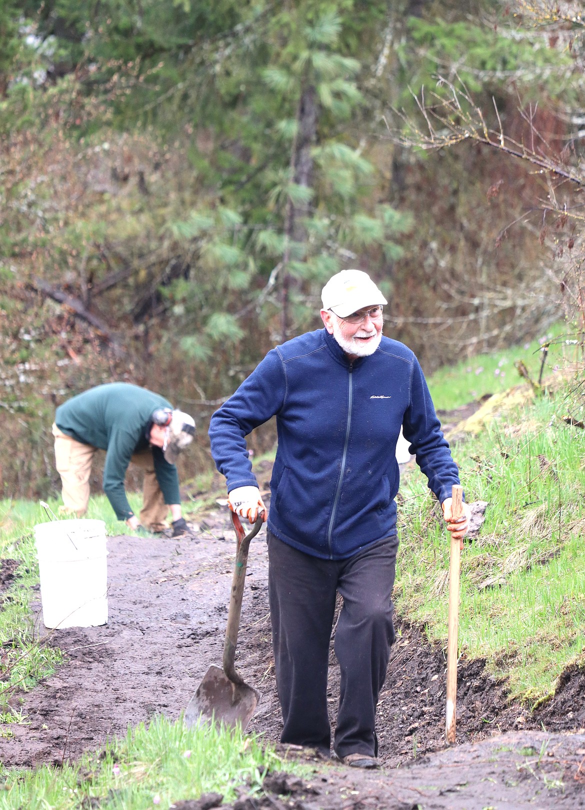 George Ives carries a shovel and Pulaski up a Tubbs Hill trail being worked on Friday.