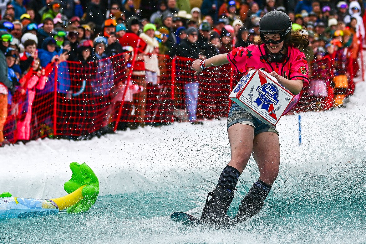 Participants ski or snowboard across the water during the pond skim at Whitefish Mountain Resort on Saturday, April 6. (Casey Kreider/Daily Inter Lake)