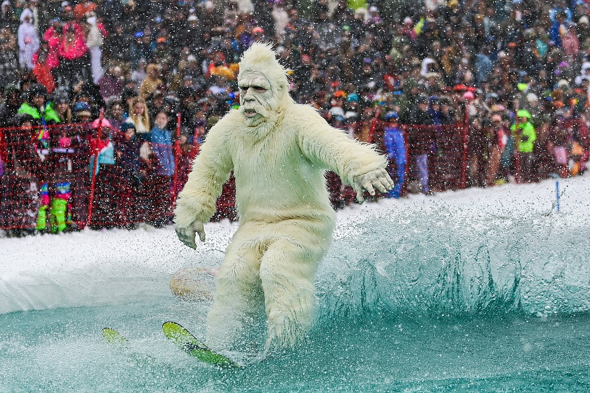 Participants ski or snowboard across the water during the pond skim at Whitefish Mountain Resort on Saturday, April 6. (Casey Kreider/Daily Inter Lake)