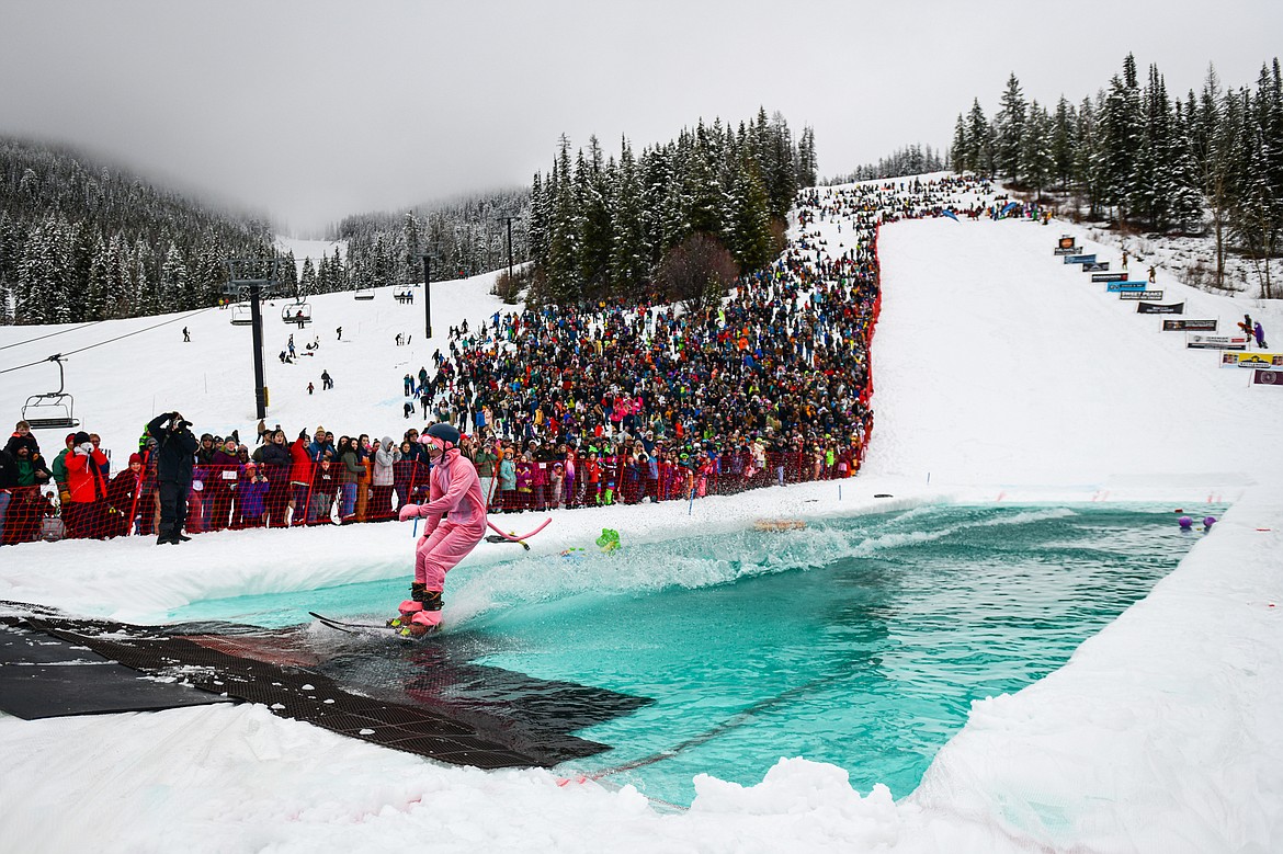 Participants ski or snowboard across the water during the pond skim at Whitefish Mountain Resort on Saturday, April 6. (Casey Kreider/Daily Inter Lake)