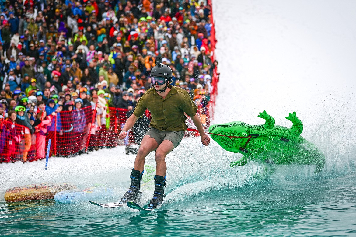 Participants ski or snowboard across the water during the pond skim at Whitefish Mountain Resort on Saturday, April 6. (Casey Kreider/Daily Inter Lake)