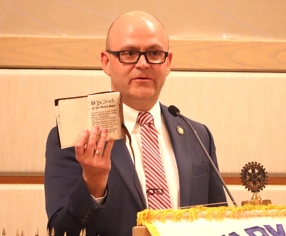 Idaho Secretary of State Phil McCrane holds up his pocket copy of the U.S. Constitution, handwritten by his father, during his speech before Coeur d'Alene Rotarians at The Coeur d'Alene Resort on Friday.