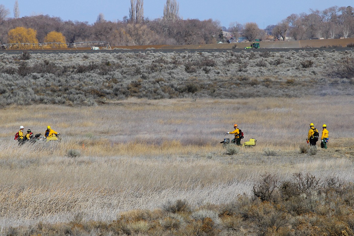 Washington Department of Fish and Wildlife crews shepherd a controlled burn near Moses Lake in 2021. A collection of agencies in Washington and Oregon will collaborate this year on increasing the use of prescribed burns to combat wildfires, among other initiatives.