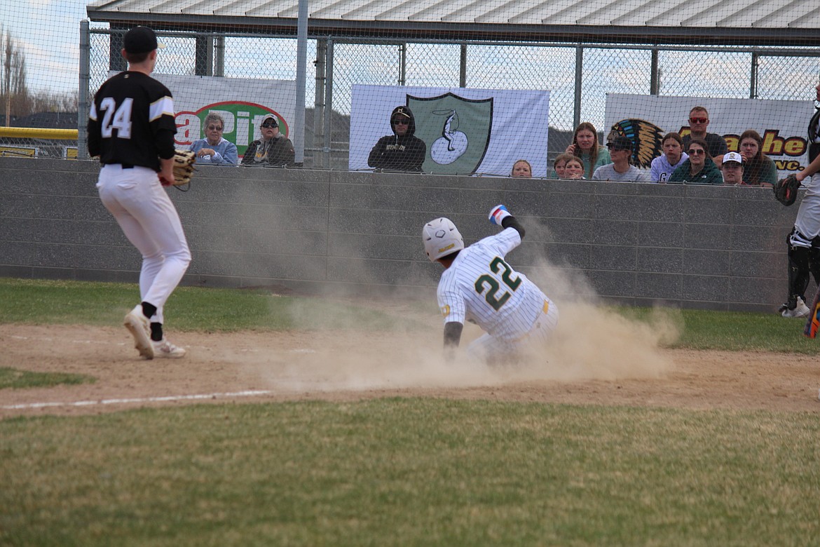 Quincy’s Evander Stephens (22) slides home on a passed ball in Quincy’s 5-2 win over Royal in the second game of a non-league doubleheader Saturday.