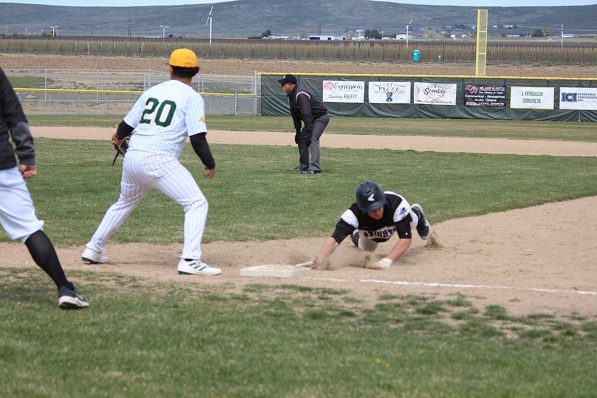 A Royal baserunner dives back to first in the Knights’ game against Quincy.