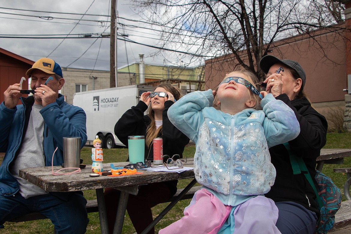 Spectators look at the solar eclipse in Kalispell on April 8, 2024, through an event hosted by the Flathead County Library and the Hockaday Museum of Art. (Kate Heston/Daily Inter Lake)