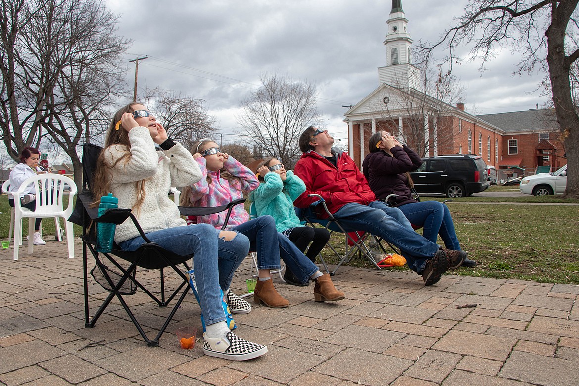 Spectators look at the solar eclipse in Kalispell on April 8, 2024, through an event hosted by the Flathead County Library and the Hockaday Museum of Art. (Kate Heston/Daily Inter Lake)