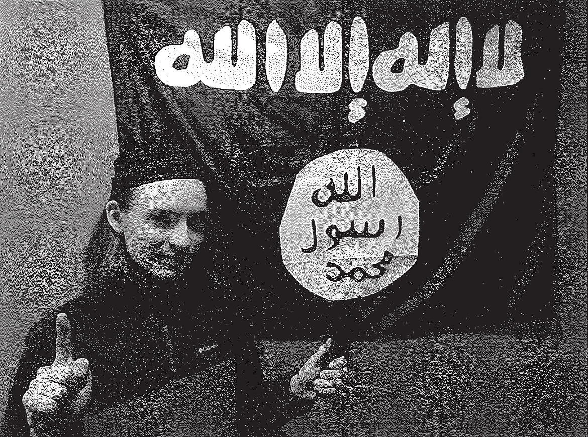Alexander S. Mercurio, 18, of Coeur d'Alene, poses in front of an Islamic State flag gifted to him by an FBI informant.