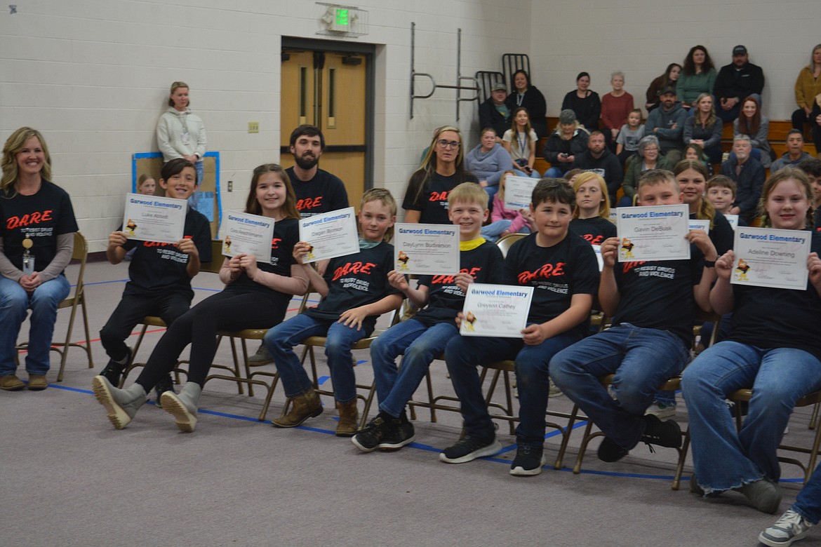 Fifth-graders at Garwood Elementary hold up their certificates after graduating from the 10-week D.A.R.E. program.