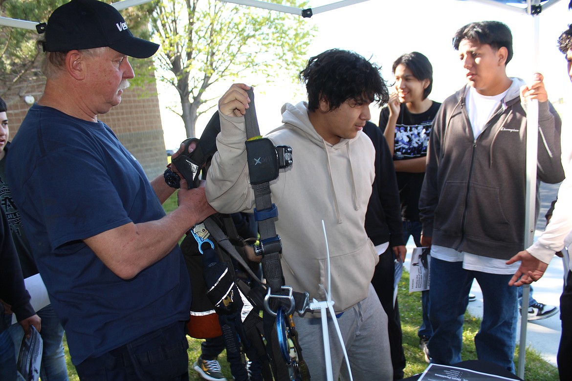 Wahluke School District student Christopher Barajas tries on a firefighting harness during the 2023 Outdoor Career Day at Wahluke High School last spring.