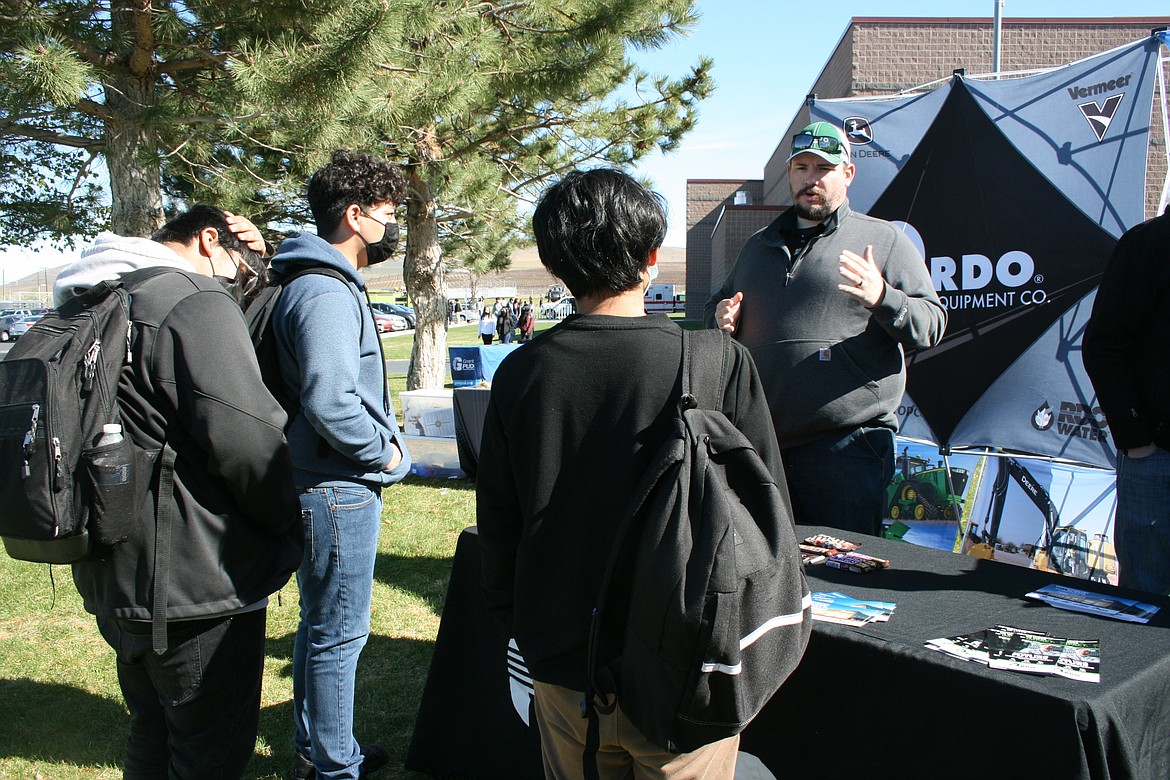 Joe Collins of RDO Equipment Company, right, talks about job opportunities with Wahluke High School students during the 2022 Wahluke School District Outdoor Career Fair.