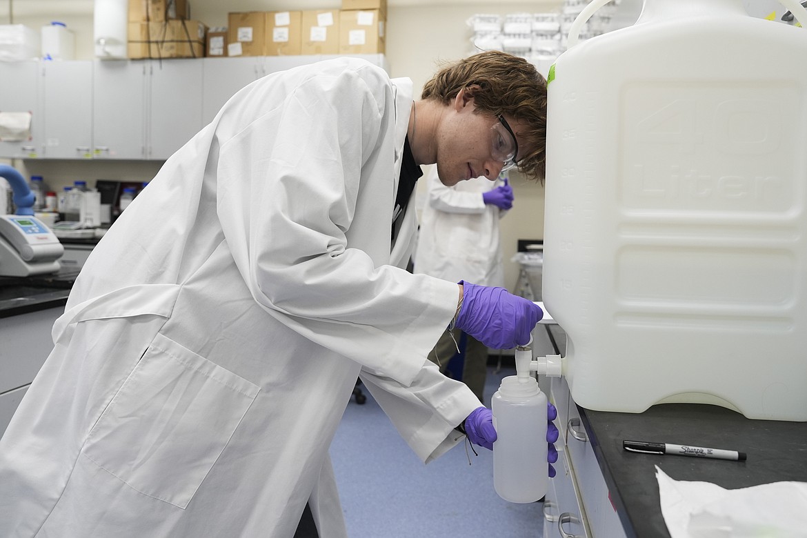 Logan Feeney pours a PFAS water sample into a container for research, Wednesday, April 10, 2024, at a U.S. Environmental Protection Agency lab in Cincinnati. The Environmental Protection Agency on Wednesday announced its first-ever limits for several common types of PFAS, the so-called "forever chemicals," in drinking water. (AP Photo/Joshua A. Bickel)