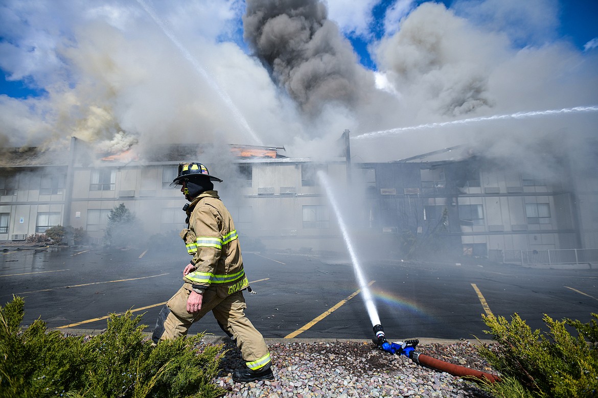 Kalispell Fire Department firefighter Ben Graham checks a hose during a fire at the Quality Inn on U.S. Highway 2 West in Kalispell on Wednesday, April 10. (Casey Kreider/Daily Inter Lake)