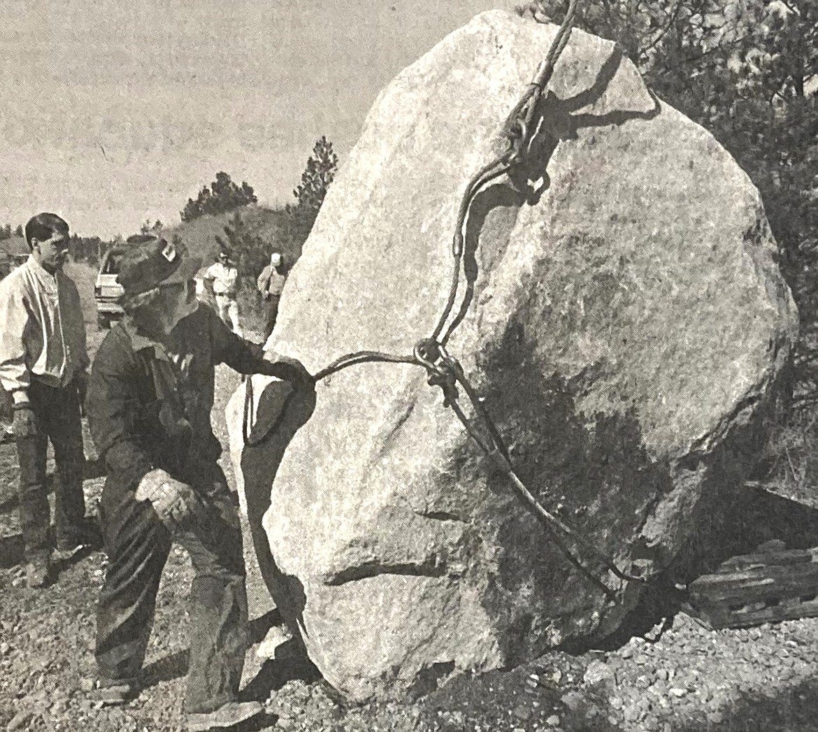 Tye Akers of Hite Crane positions cables to place Centennial Rock at the state line.