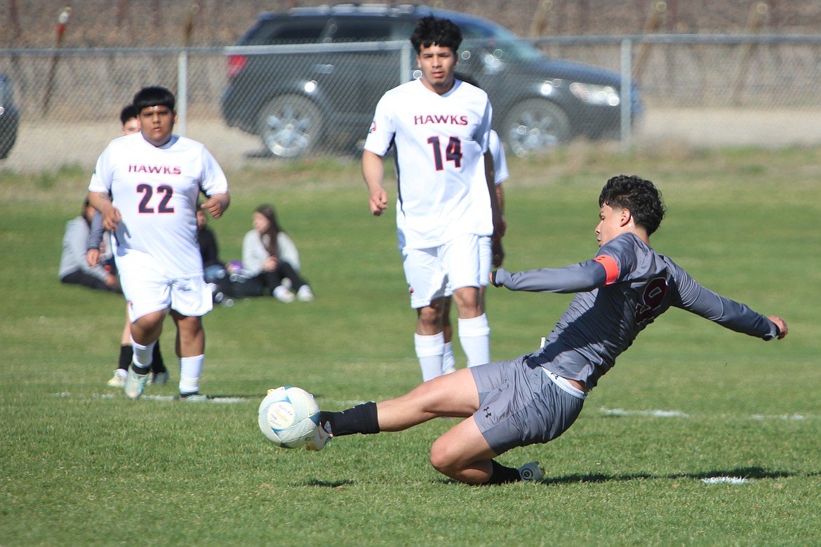 Wahluke senior Diego Olivares (9) slides while shooting the ball in the first half against College Place. Olivares scored two goals in less than a minute to begin the game.