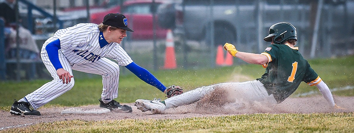 Columbia Falls third baseman Jett Pitts (26) puts a tag on Whitefish's Ryan Conklin (1) on a throw from right fielder Matthew Mitts at Sapa-Johnsrud Field on Thursday, April 11. (Casey Kreider/Daily Inter Lake)