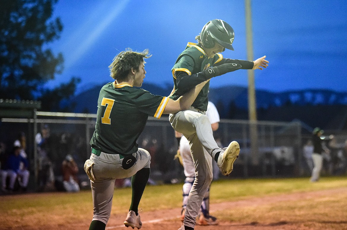 Whitefish's Reed Boyer (7) and Drew Queen (22) celebrate after Queen scored in the fifth inning against Columbia Falls at Sapa-Johnsrud Field on Thursday, April 11. (Casey Kreider/Daily Inter Lake)