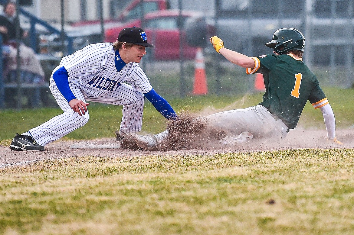 Columbia Falls third baseman Jett Pitts (26) puts a tag on Whitefish's Ryan Conklin (1) on a throw from right fielder Matthew Mitts at Sapa-Johnsrud Field on Thursday, April 11. (Casey Kreider/Daily Inter Lake)
