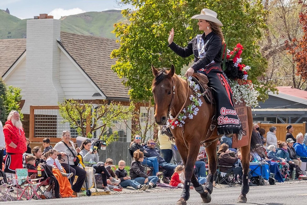 The Moses Lake Roundup queen waves to the crowd during the 2023 Wenatchee Apple Blossom Festival grand parade.